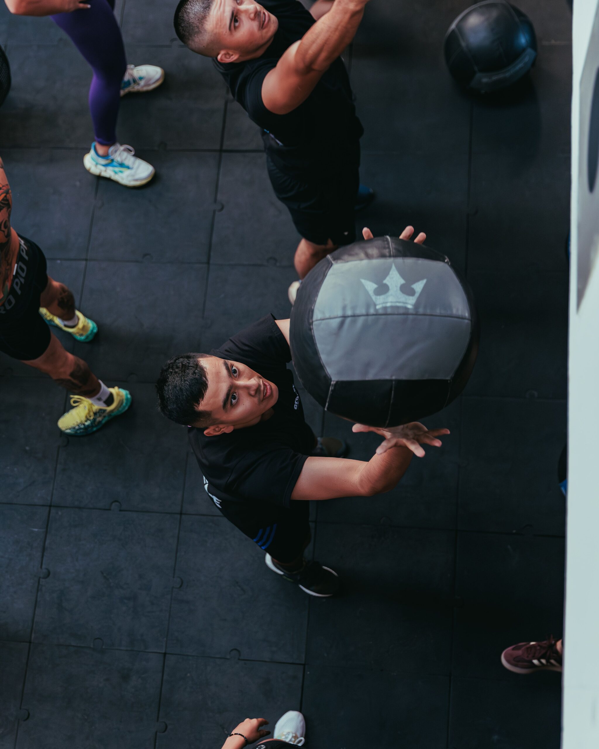 Two clients training together with their personal trainer